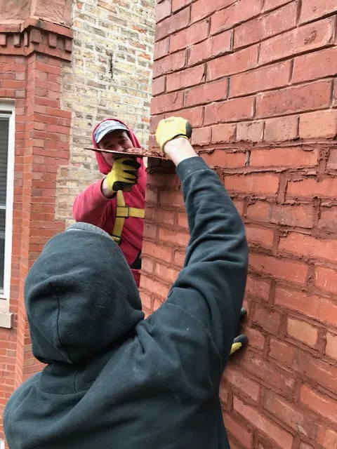 renovating exterior brick wall by tuckpointing service