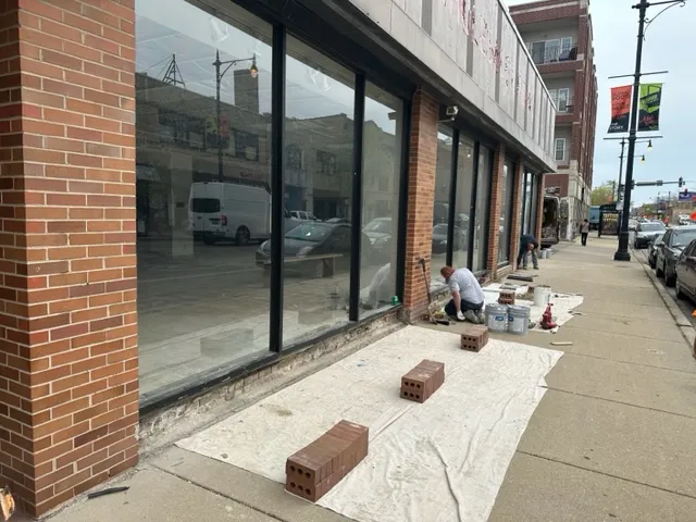 masonry contractors adding new layer of bricks on commercial building