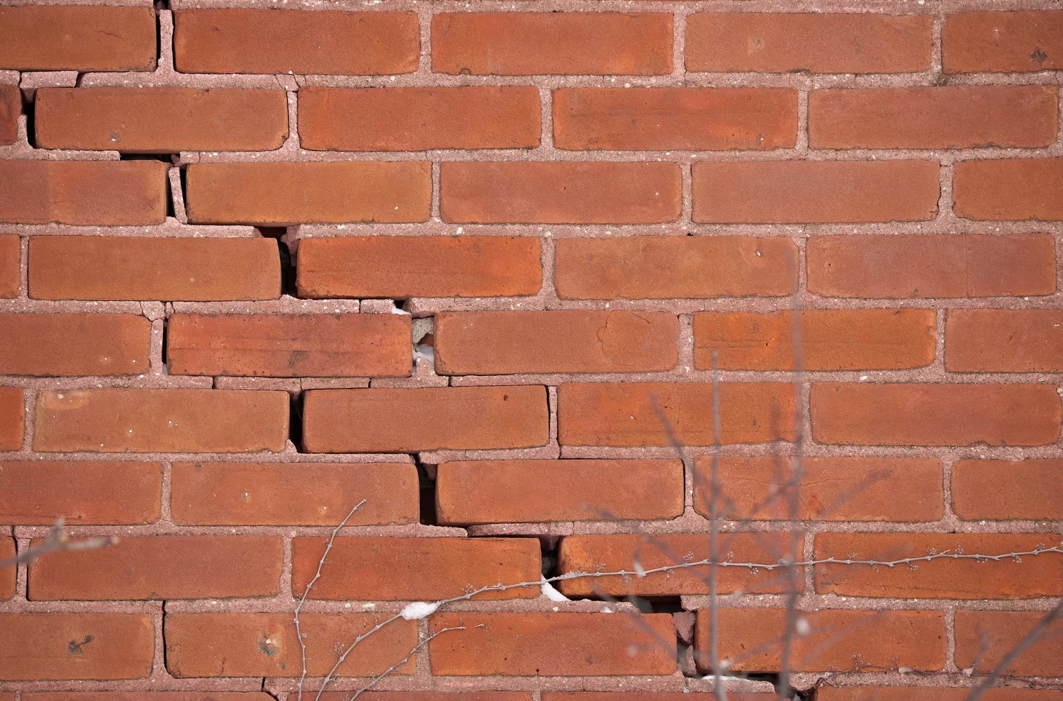 Red Brick Wall with Large Crack and crumbling mortar